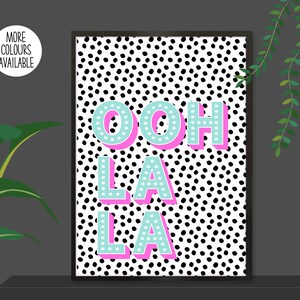 以下が含まれることがあります： 黒と白のドット柄に、ピンクとターコイズの文字で「ooh la la」と書かれたプリントです。