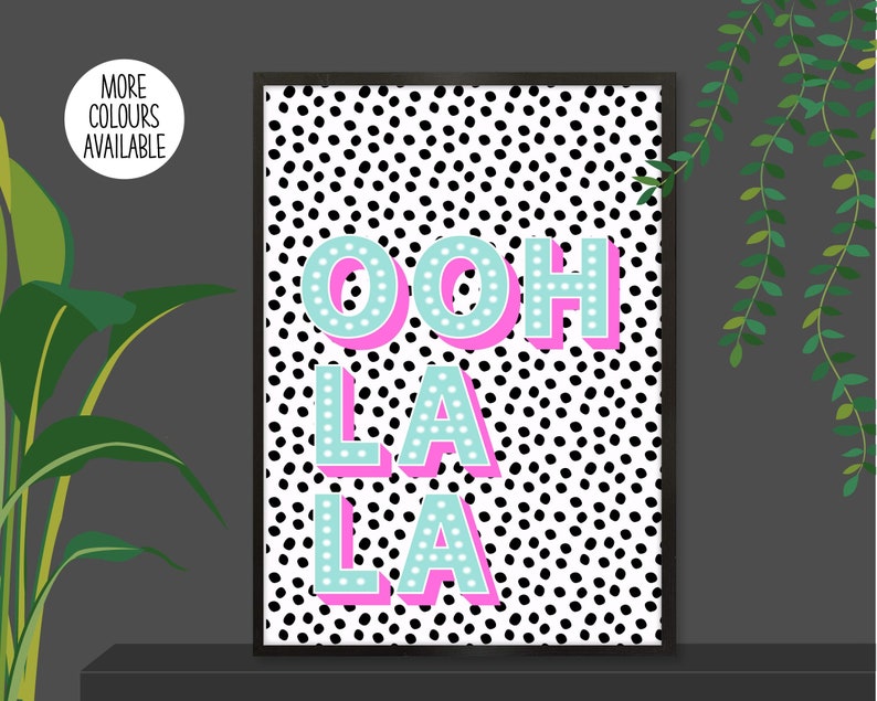 以下が含まれることがあります： 黒と白のドット柄に、ピンクとターコイズの文字で「ooh la la」と書かれたプリントです。