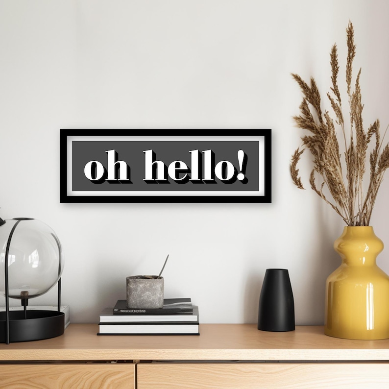 May include: Black and white framed wall art with the text "oh hello!" in a retro font.