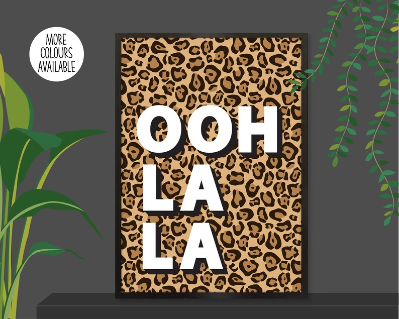 以下が含まれることがあります： ヒョウ柄の背景に「ooh la la」という白い太字のテキストが書かれた、印刷可能な壁の芸術デザインです。