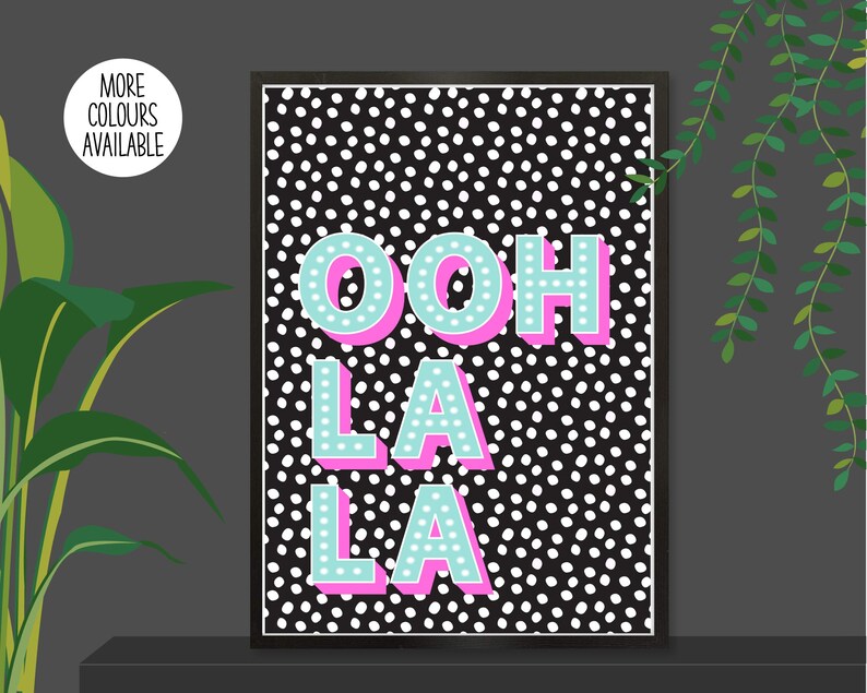 以下が含まれることがあります： 黒と白のドット柄に「OOH LA LA」という文字がターコイズとピンクの文字で書かれています。