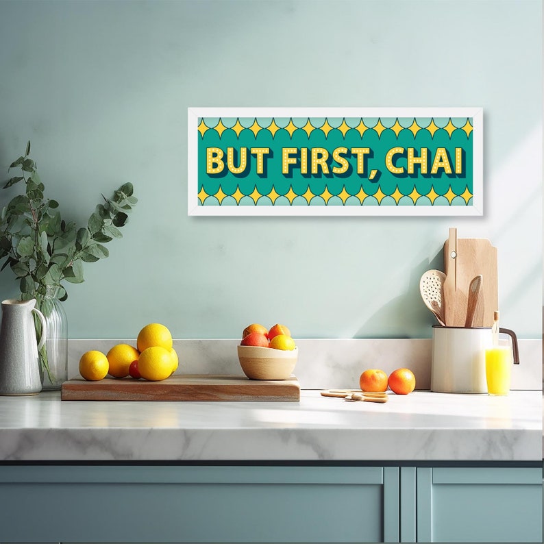 May include: A white framed print with a teal background and yellow text that reads "BUT FIRST, CHAI". The text is outlined in black and has a glittery effect. The background is decorated with a pattern of yellow stars.