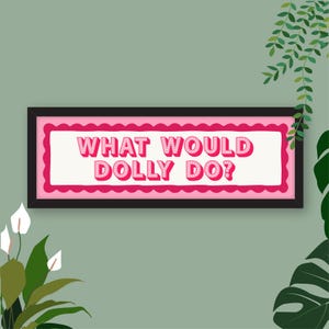 May include: A rectangular wall sign in a black frame featuring a white centre with a scalloped hot pink border. The text WHAT WOULD DOLLY DO? is printed in a bold, three-dimensional pink font with white dots, centred within the frame.