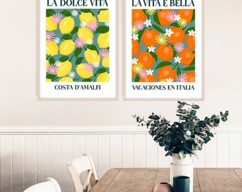 May include: Two framed prints with a green background and colorful fruit illustrations. The left print features lemons and the text "LA DOLCE VITA" and "COSTA D'AMALFI". The right print features oranges and the text "LA VITA E BELLA" and "VACACIONES EN ITALIA".