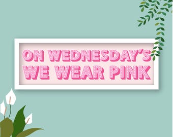 May include: A white framed sign with pink text that reads "On Wednesday's We Wear Pink" against a light blue background.