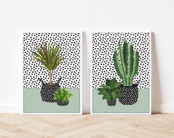 May include: Two framed prints with black and white polka dot backgrounds. Each print features a potted plant in a black and white polka dot pot. The plant on the left is a green palm tree. The plant on the right is a green cactus.