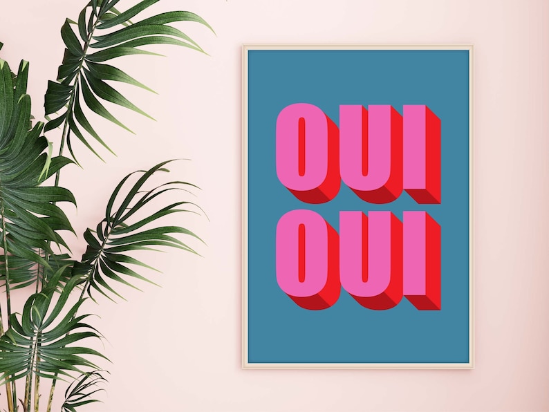 May include: A framed print with a blue background and the word "OUI" written in pink and red letters with a 3D effect.