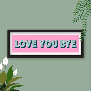 May include: A framed print with a pink background and the text "LOVE YOU BYE" in teal blue letters with white polka dots.