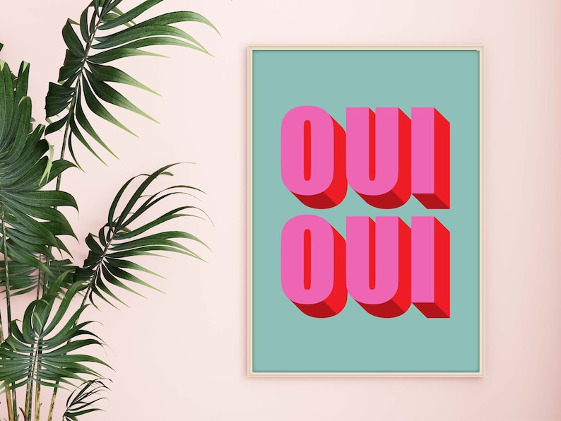 May include: A framed print with a teal background and the word "OUI" written twice in pink and red 3D letters.