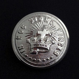 May include: A silver-toned button with a raised design featuring a crown, a star, and the words "In Hoc Signo Vinces".