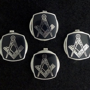 May include: Four silver-toned cufflinks with black enamel and a silver compass and square design.