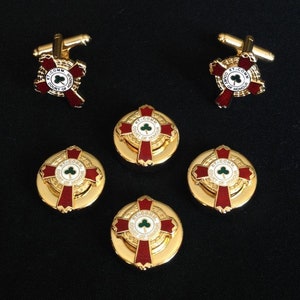 May include: Set of five gold-tone cufflinks and buttons featuring a red cross with a green shamrock in the center. The cross is surrounded by a gold ring with the text "KT.COMM COURT OF HONOR".