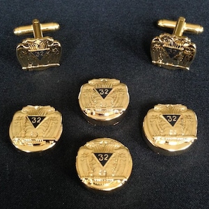 May include: Set of six gold-toned cufflinks and buttons featuring a black eagle design with the number 32 in a triangle.