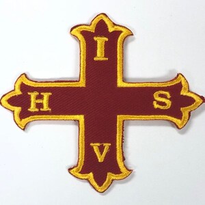 May include: A red embroidered cross with a gold outline and the letters "IHS" and "V" in gold.