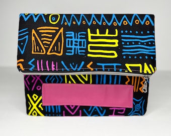 May include: Black clutch purse with a zipper closure and a pink leather flap. The purse is decorated with colorful geometric patterns.