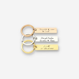 Puede incluir: Tres llaveros de oro, plata y oro rosa con mensajes grabados. El llavero superior dice "Te amo hasta la luna y de regreso, Camille". El llavero del medio dice "Conduce con cuidado, te necesito aquí conmigo, Victoria". El llavero inferior dice "L & M, 27 de abril de 2020".