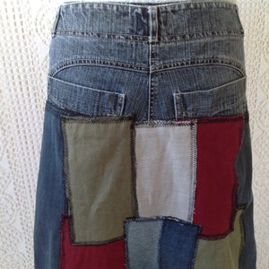 K&ouml;nnte beinhalten: Ein Jeansrock mit Patchwork-Design. Der Rock besteht aus verschiedenen Stoffen in den Farben Blau, Gr&uuml;n, Rot und Wei&szlig;. Der Rock hat eine hohe Taille und eine gerade Silhouette.