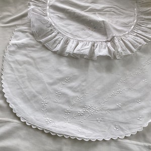Può includere: Due tovagliette all'uncinetto in cotone bianco con bordi a festoni e delicati ricami floreali. La tovaglietta più grande ha un bordo arricciato.