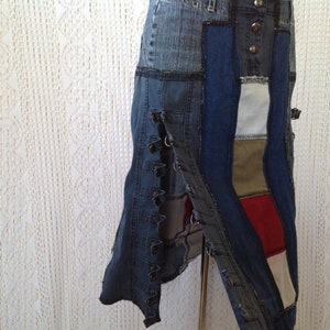 K&ouml;nnte beinhalten: Ein Jeansrock mit Patchwork-Design in verschiedenen Blaut&ouml;nen, Wei&szlig;, Rot und Braun. Der Rock hat eine lange, flie&szlig;ende Silhouette und wird mit einer Reihe von Kn&ouml;pfen an der Vorderseite befestigt.