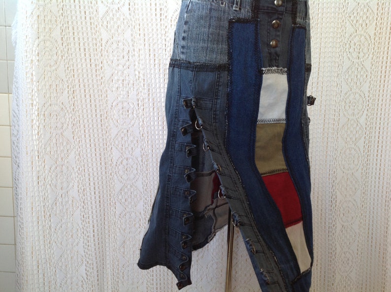 K&ouml;nnte beinhalten: Ein Jeansrock mit Patchwork-Design in verschiedenen Blaut&ouml;nen, Wei&szlig;, Rot und Braun. Der Rock hat eine lange, flie&szlig;ende Silhouette und wird mit einer Reihe von Kn&ouml;pfen an der Vorderseite befestigt.