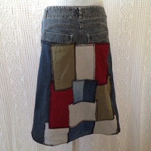 K&ouml;nnte beinhalten: Ein Jeansrock mit Patchwork-Design. Der Rock besteht aus verschiedenen Stoffen in den Farben Blau, Rot, Gr&uuml;n und Wei&szlig;.