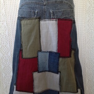 K&ouml;nnte beinhalten: Ein Jeansrock mit Patchwork-Design. Der Rock besteht aus verschiedenen farbigen Jeans- und Stoffresten, darunter Rot, Blau, Gr&uuml;n und Grau. Der Rock hat eine hohe Taille und eine ausgestellte Silhouette.