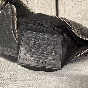 Pu&ograve; includere: Borsa Coach in pelle nera con chiusura a zip e cuciture bianche. La borsa ha una superficie strutturata e un'etichetta in pelle nera all'interno con testo e il numero H0782-F10891.
