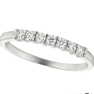May include: A thin silver band with a row of small, round diamonds set in a pave setting.