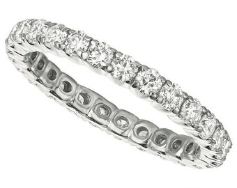 May include: A silver eternity band with a row of round brilliant diamonds set in a pave setting.