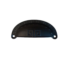 May include: A black, semi-circular drawer pull with a decorative Greek key pattern. The hardware features two mounting holes and a central design element. This cabinet pull is made of metal.