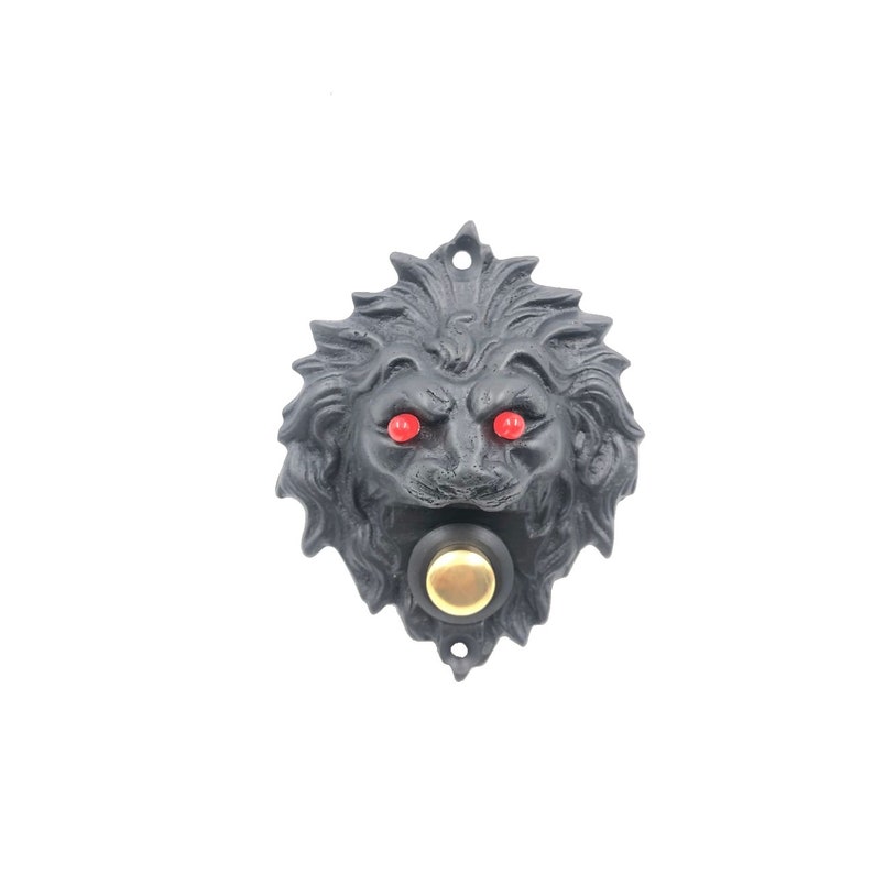 May include: Black cast iron door knocker shaped like a lion's head with red eyes and a gold button.