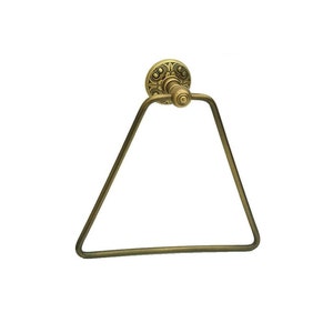 以下が含まれることがあります： 装飾的なベースが付いた、ゴールドトーンの三角形のタオルリングです。