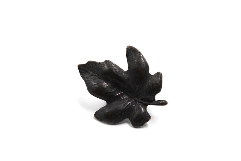 May include: A black metal leaf-shaped decorative accent. The leaf has a detailed, textured surface.
