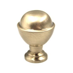 Könnte beinhalten: Ein Knopf aus gebürstetem Nickel für Schränke mit einer runden, leicht gewölbten Oberseite und einem dekorativen Sockel.