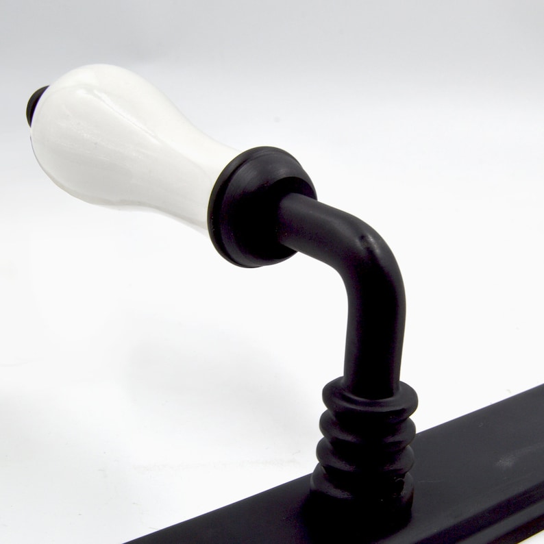 May include: Black and white porcelain door handle with a white ceramic lever and a black metal base.