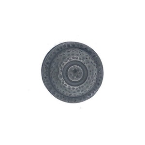 Op de afbeelding: Een ronde, zilverkleurige metalen knop met een gehamerde textuur en een concentrisch cirkelontwerp.