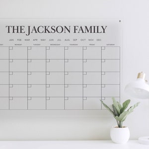 May include: A white dry-erase calendar with the text "THE JACKSON FAMILY" at the top. The calendar has the months of the year listed across the top and the days of the week listed down the side.