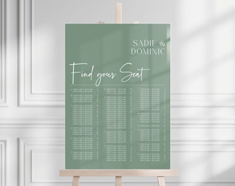 May include: A sage green wedding seating chart on a wooden easel. The chart features the names "Sadie & Dominic" and the text "Find your Seat" in elegant white script. Below, guest names are listed in columns.