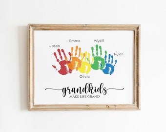 May include: A framed print with a rainbow of handprints, each labeled with a name: Jason, Emma, Wyatt, Olivia, and Rylan. The text "grandkids MAKE LIFE GRAND" is below the handprints.