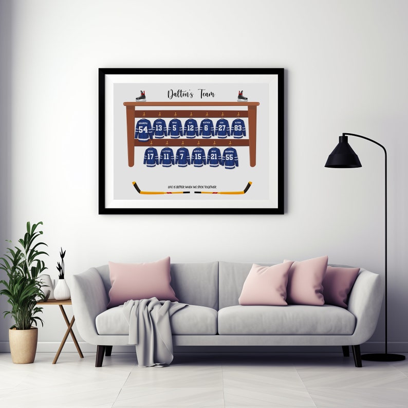 May include: A framed print showing a hockey team's jerseys on a wooden rack. The blue and white jerseys each have a number. The print includes the text "Dalton's Team" and a quote about teamwork. Two hockey sticks are at the bottom of the print.