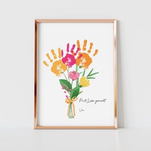 Peut inclure: Impression d'art encadrée avec un bouquet de fleurs et des empreintes de mains roses, oranges et jaunes. L'œuvre comprend le texte "Mit Liebe gemacht" et "Von" en écriture noire, sur fond blanc, dans un cadre cuivré.