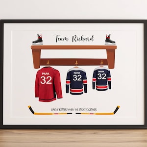 May include: Framed print featuring hockey-themed artwork. It displays three jerseys with the numbers 32, labeled "Papa," "Mama," and "Mark." Above, a bench holds hockey skates. The text "Team Richard" is at the top, with the phrase "Life is better when we stick together" at the bottom.