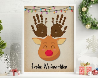 May include: A brown reindeer with a red nose and handprint antlers. The reindeer is smiling and has a festive string of lights above it. The text "frohe Weihnachten" is written below the reindeer.