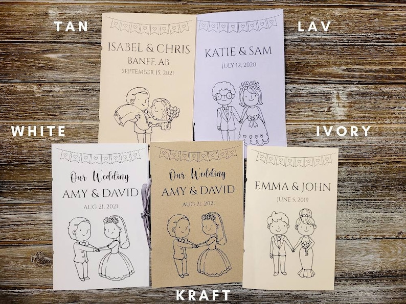 Pu&ograve; includere: Una collezione di programmi di nozze in vari colori, tra cui beige, bianco e avorio. Ogni programma presenta un'illustrazione di una coppia e include i nomi e la data del matrimonio. Sono disposti su una superficie di legno.