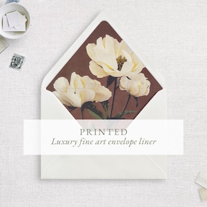 May include: A white envelope with a pointed flap featuring an interior liner printed with a dark brown background and cream-colored peony flowers. The text PRINTED Luxury fine art envelope liner is centered across the middle of the envelope.