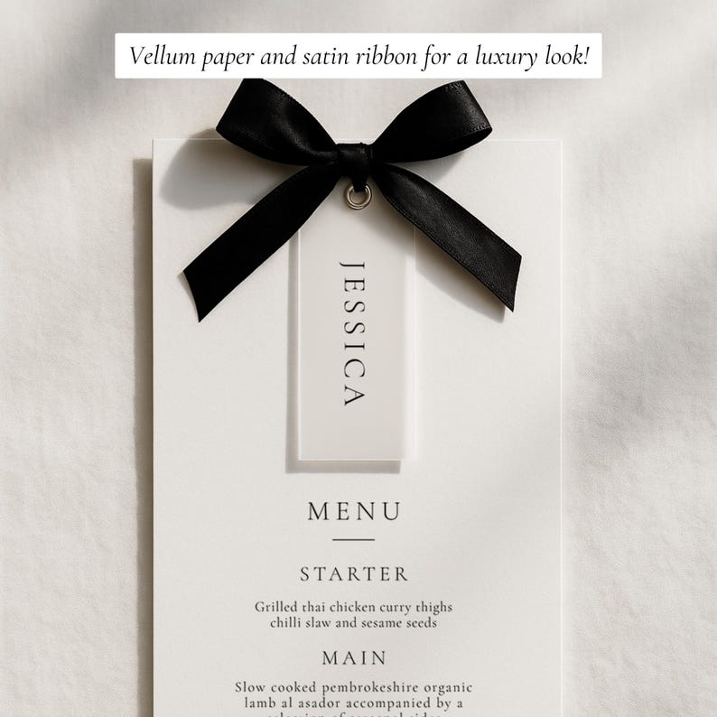 May include: A white menu card with the name "JESSICA" on a tag, tied with a black satin ribbon. The menu includes "STARTER" and "MAIN" course options. Text at the top reads "Vellum paper and satin ribbon for a luxury look!"