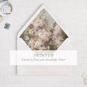 Op de afbeelding: Een witte envelop met een bloemenprint voering. De voering heeft een aquarel-achtige schildering van witte en roze bloemen. Tekst op de envelop luidt "PRINTED Luxury fine art envelope liner."