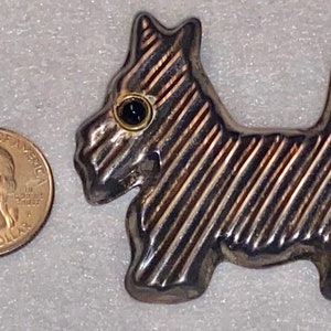 925 signed Hencho en Mexico Tv-49? Scottie dog Pin. Also I believe has a black onyx stone for eye. 20.2 g