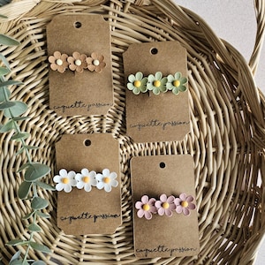 May include: Four sets of three-flower hair clips on brown cards with the text "coquette passion". The flowers are in shades of brown, green, white, and pink.
