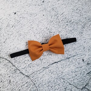 May include: A brown bow tie with a black elastic band.